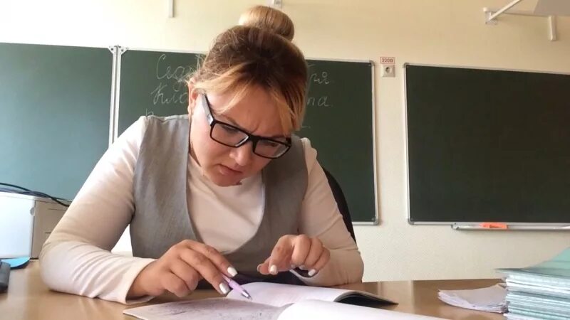 Преподаватель проверка работ. Учитель проверяет. Учительница проверяет тетради. Педагог проверяет тетради. Учитель собирает тетради.