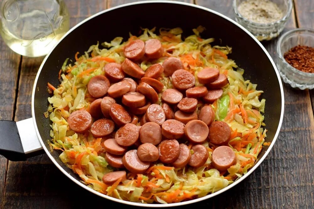 Тушёная капуста с сосисками на сковороде. Капуста тушёная с сосисками на сковороде с томатной пастой. Тушёная капуста с сосисками. Тушёная капуста с сосисками. Вкусная тушеная капуста с сосисками на сковороде.