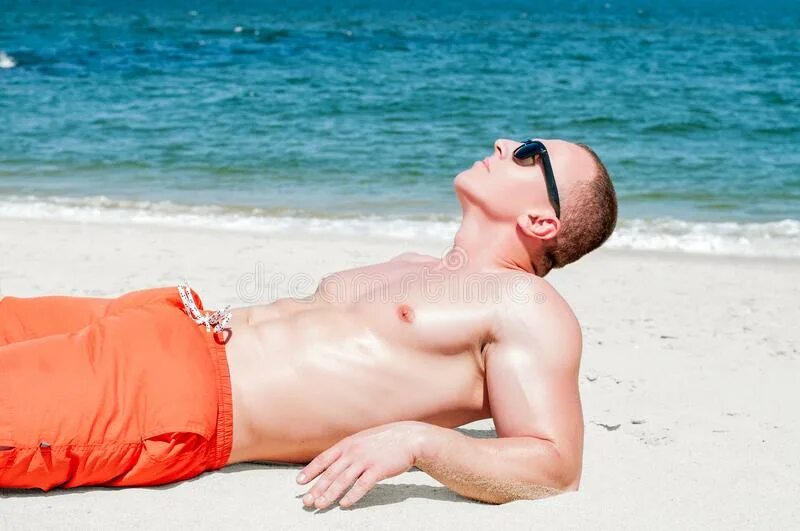 Парень лежит на пляже. Лежа на пляже мужчина. Гол пляж муж