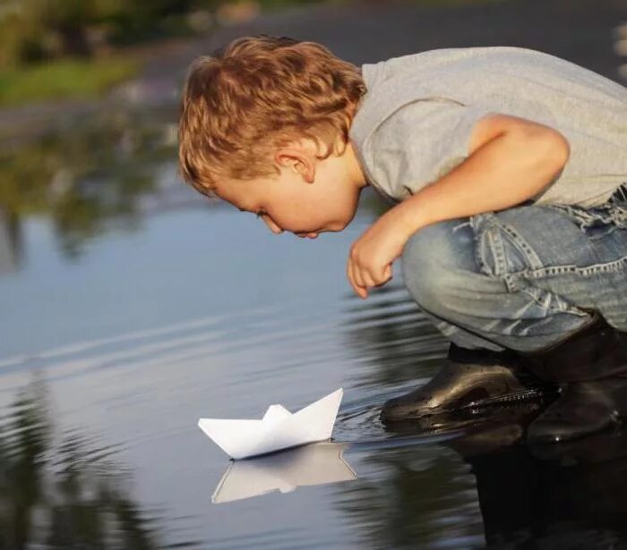 Кораблик из бумаги я по ручью пустил. Мальчик с корабликом. Ребенок с бумажным корабликом. Дети пускают бумажные кораблики. Кораблик для детей.