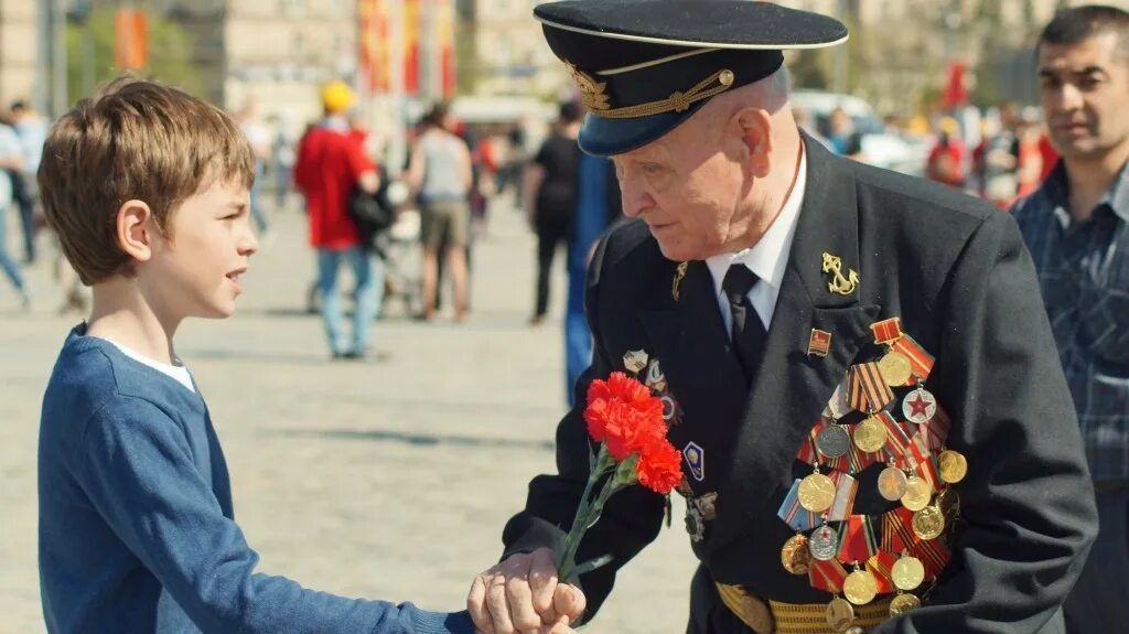 Цветы ветеранам. Дети дарят цветы ветеранам. Мальчик дарит цветы ветерану. Девочка дарит цветы ветерану.