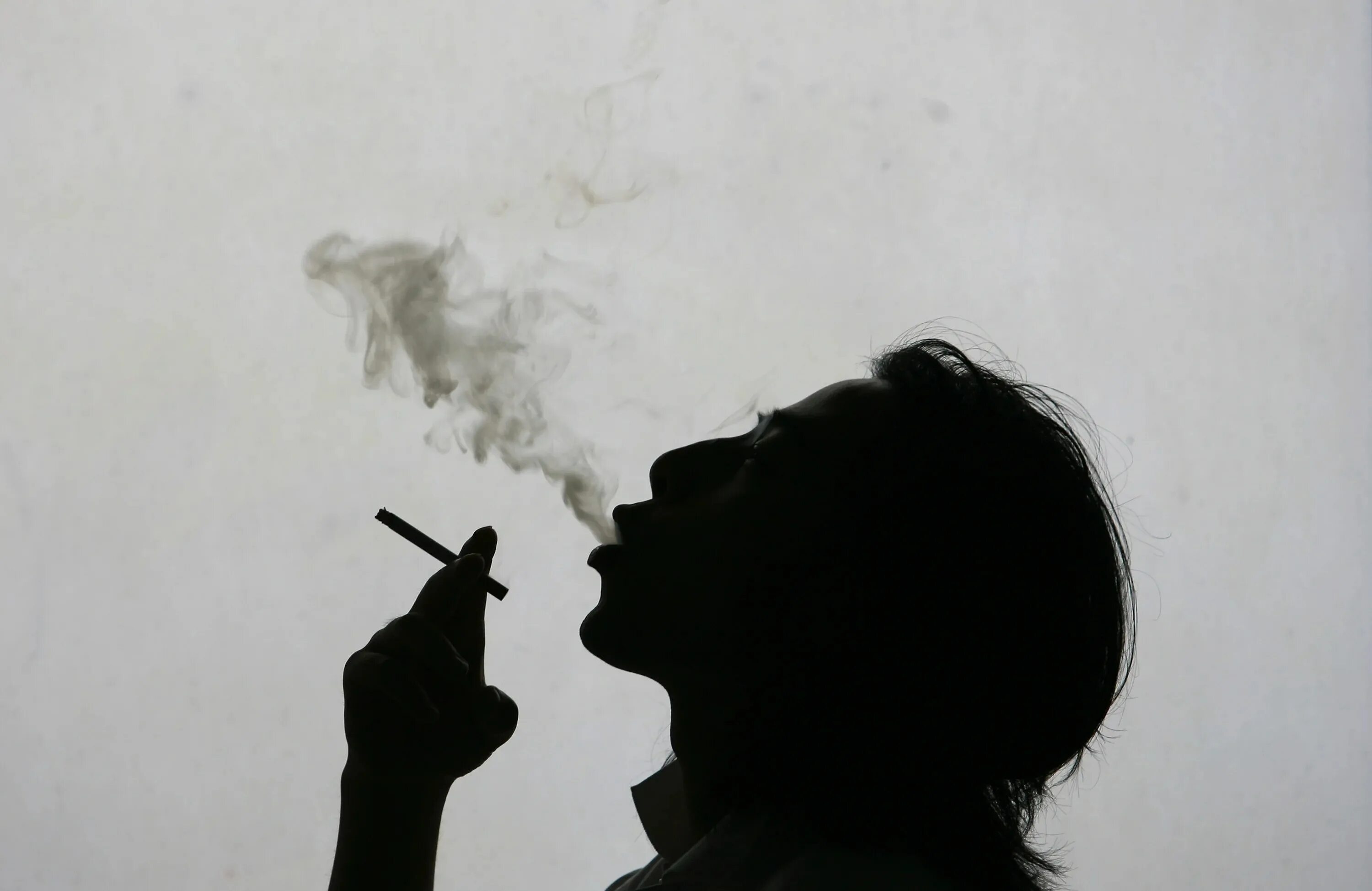Курящий человек. Дым сигарет. Человек закуривает сигарету.