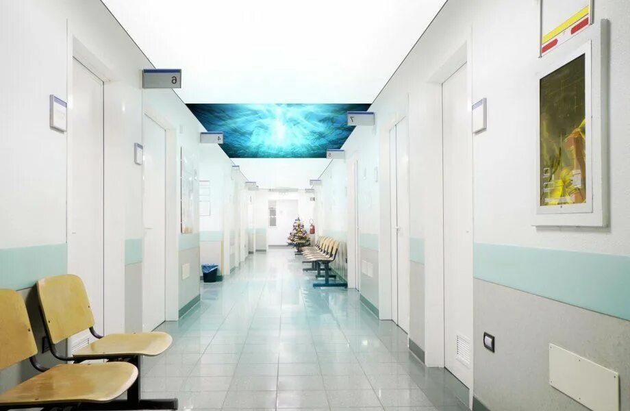 Коридор клиники фото Long hospital bright corridor with rooms and seats 3D rendering фотография Stock