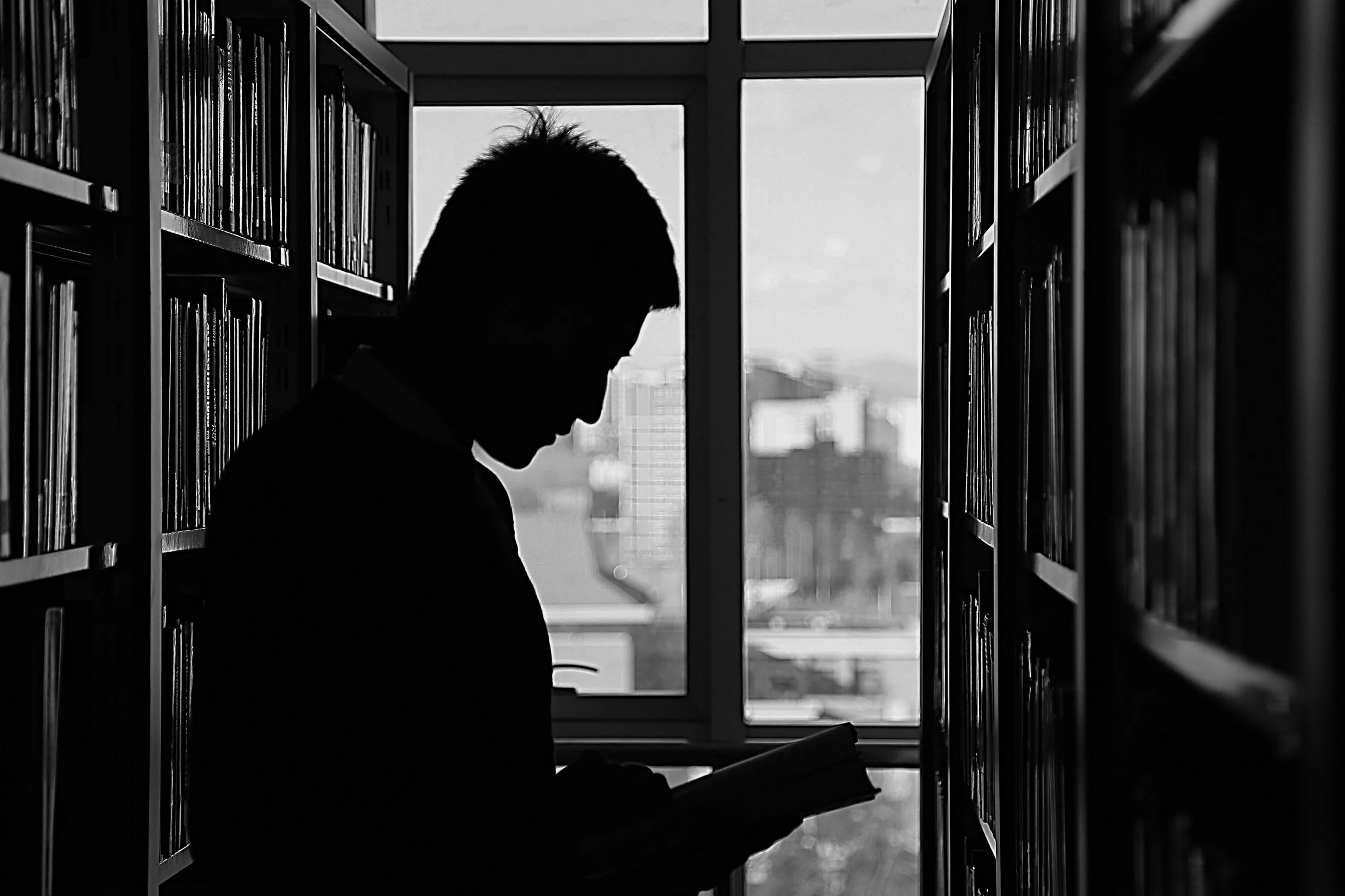Книги полная темнота. Книга человек. Парень с книгой. Мужчина в библиотеке. Чтение в темноте.
