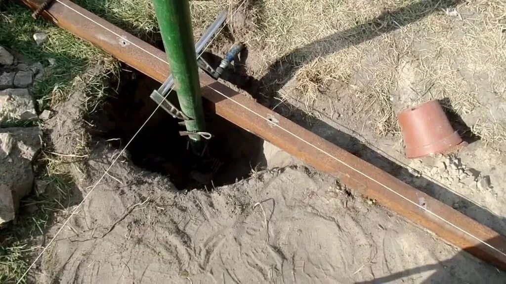 Бутование столбов забора схема. Монтаж столбов. Распорки для столбов забора. Бетонирование столбов для забора м300. Установка трубы в землю.