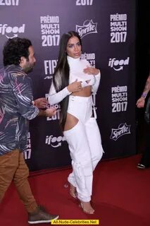 Singer Anitta sexy in white outfit at red carpet.