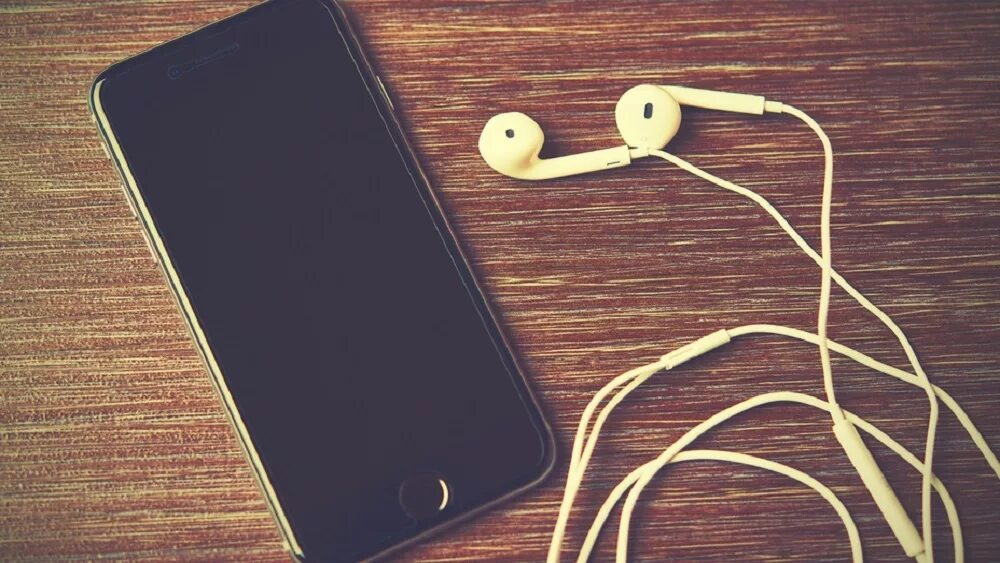 Какой айфон с наушниками. Айфон 7 с наушниками. наушники стол айфон. смартфон на столе. айфон с наушниками на столе.