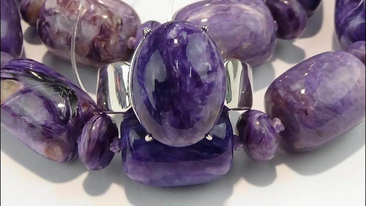 Сиреневый камень чароит. Чароит кристалл. Сиреневый камень чароит якутия. Чароит и аметист. Чароит камень.