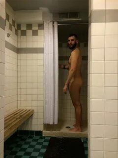 Photo d'un homme nu et barbu dans sa douche.