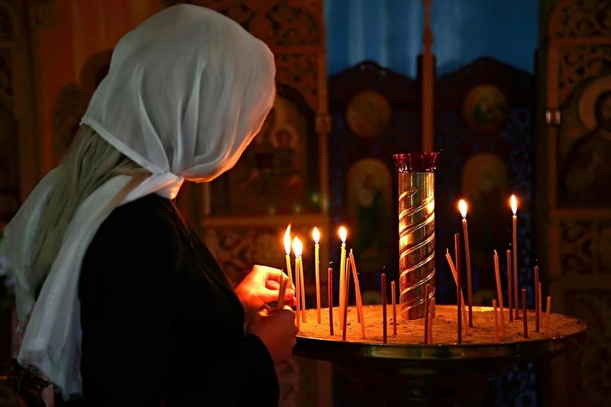 Свечи в церкви. Девушка молится в храме. Женщина со свечой в храме. Девушка в храме. Ставить свечку в храме