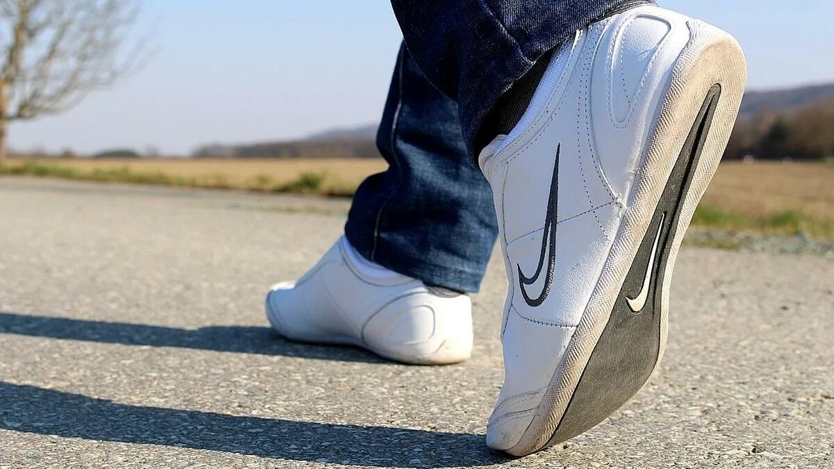 I use on foot. Фото ног. человек идет в кроссовках. walk on foot или go on foot. sports shoes.