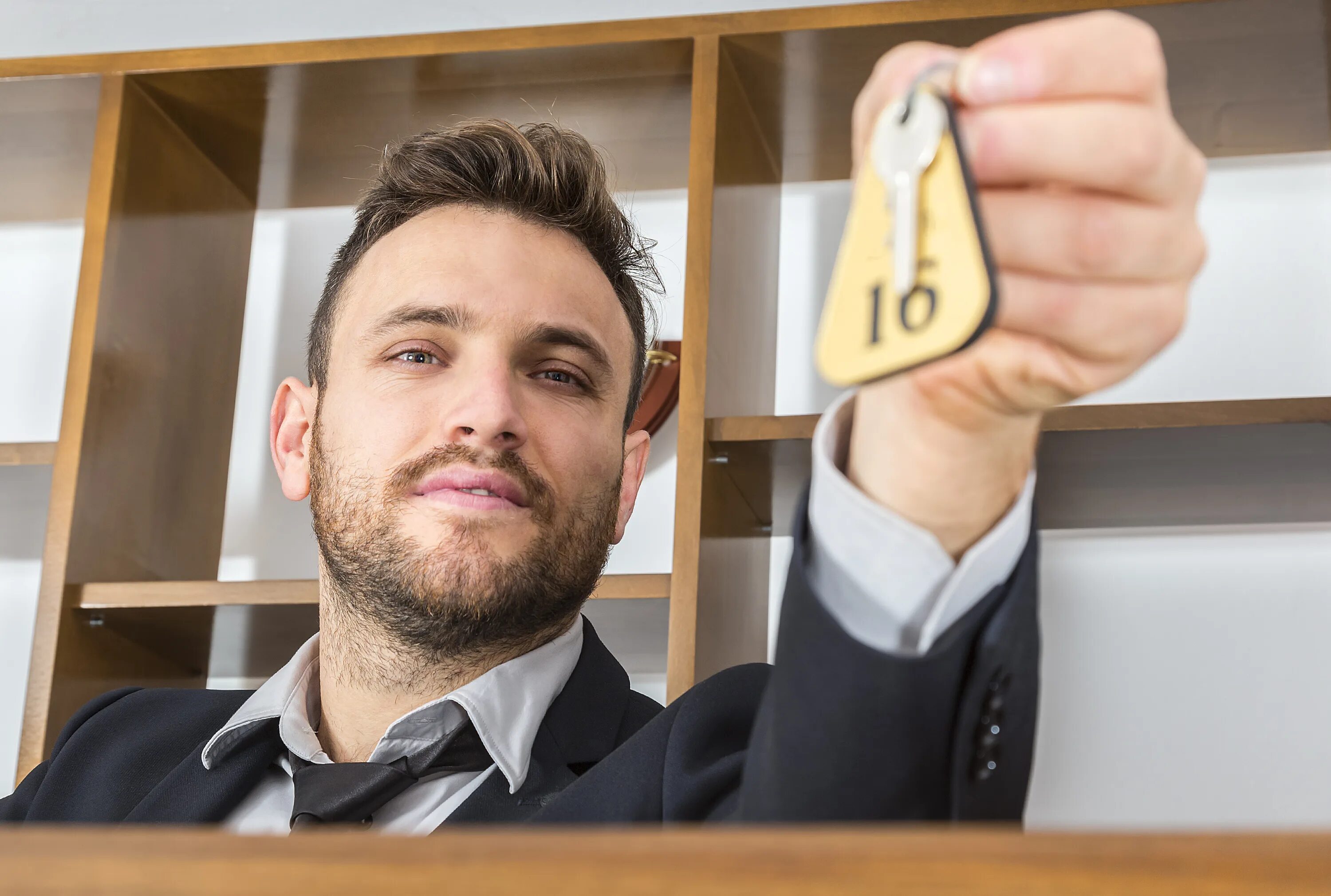 Мужчина дает ключи. How to give a Room Key to a Guest at the Reception check in.