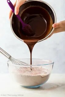 Pouring melted chocolate and coconut oil into the dry ingredients. 
