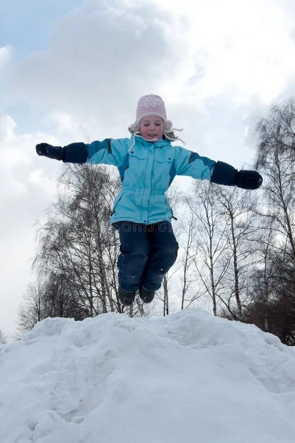 Дети прыгают зимой. Дети зимой прыгают в сугробы. Дети прыгают в сугроб. Девочка прыгает в сугроб.