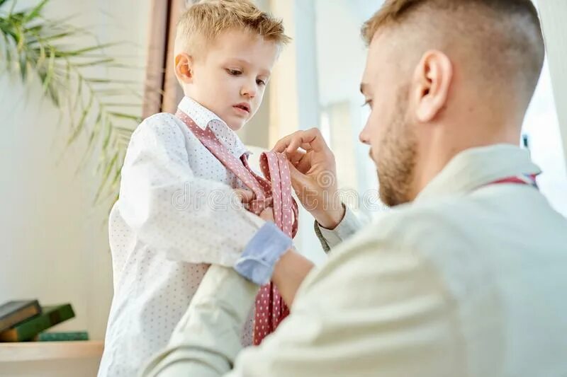Папа наряжается. Мужчина надевает ребенка. Взрослый ведет ребенка в мир. Папа одевает ребенка смешно. Отец переодевает ребенка.