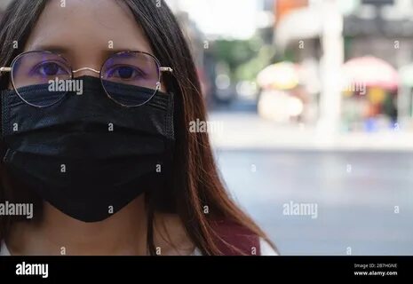 Diverse Asian girl, wearing protective face mask to protect city pollution ...