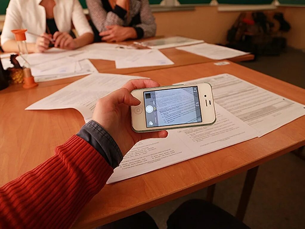 Много время егэ. Списывает с телефона. списывает с телефона на уроке. школьники списывают на егэ. списывание на егэ.
