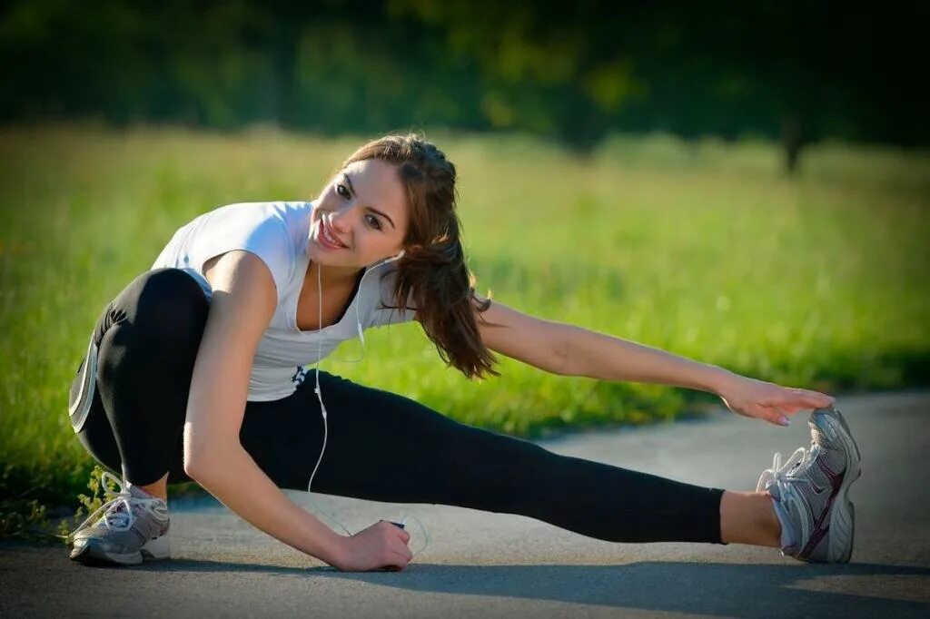 Перед бегом нужно. Девушка спорт. Разминка. Девушка разминается. Физические упражнения.