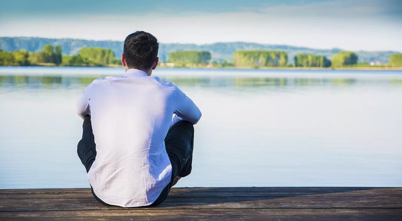 задумчивый человек на природе. парень грустит. человек сидит на обрыве. книга природа. виктор гюго высказывания.