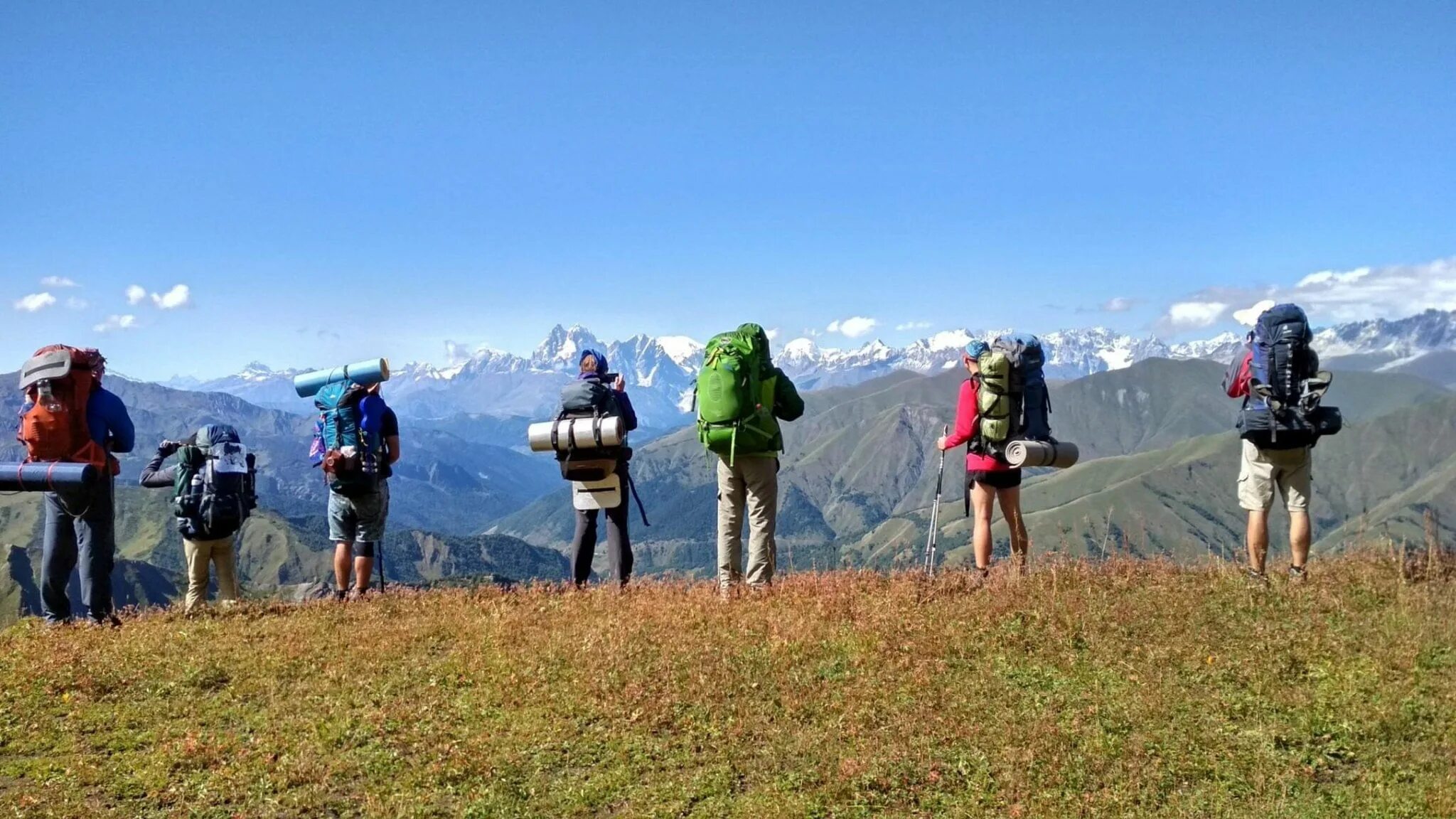 4 туриста группы готовятся к походу. Турист с рюкзаком. Поход в горы. Туристы в походе. Турист с рюкзаком в горах.