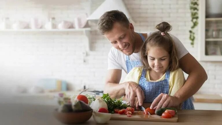 Дочки дают отцам на кухне после приготовления пищи