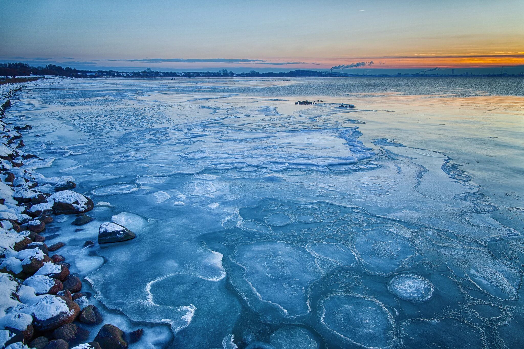 Вода покрыта льдом. Холодное море. Ледяной берег. Замерзшее море. Снежное море.