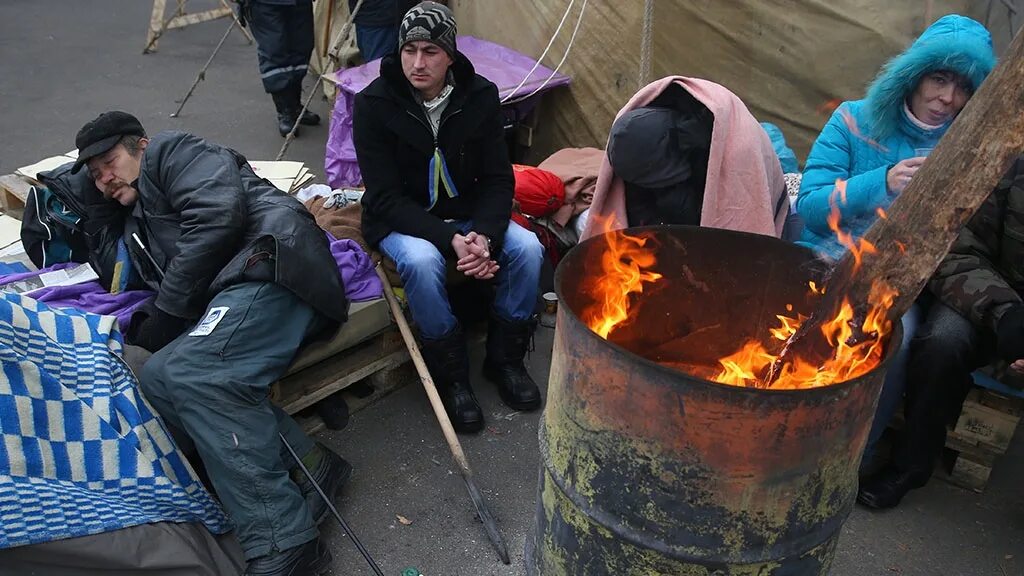 Перед бомжей. Бездомные у бочки с огнем.