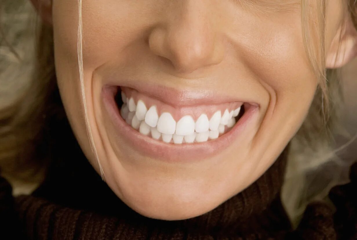 Видны верхние зубы. Красивые зубы. Красивые ровные зубы. Красивая улыбка. Красивая форма зубов.