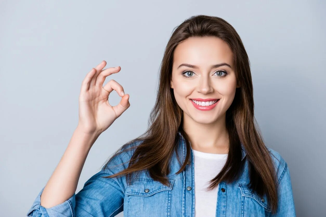 Две девочки на белом фоне. Подруги прощаются. Разговор двух подруг. Девочки рассказываю и показываю. Две девушки шепчутся.