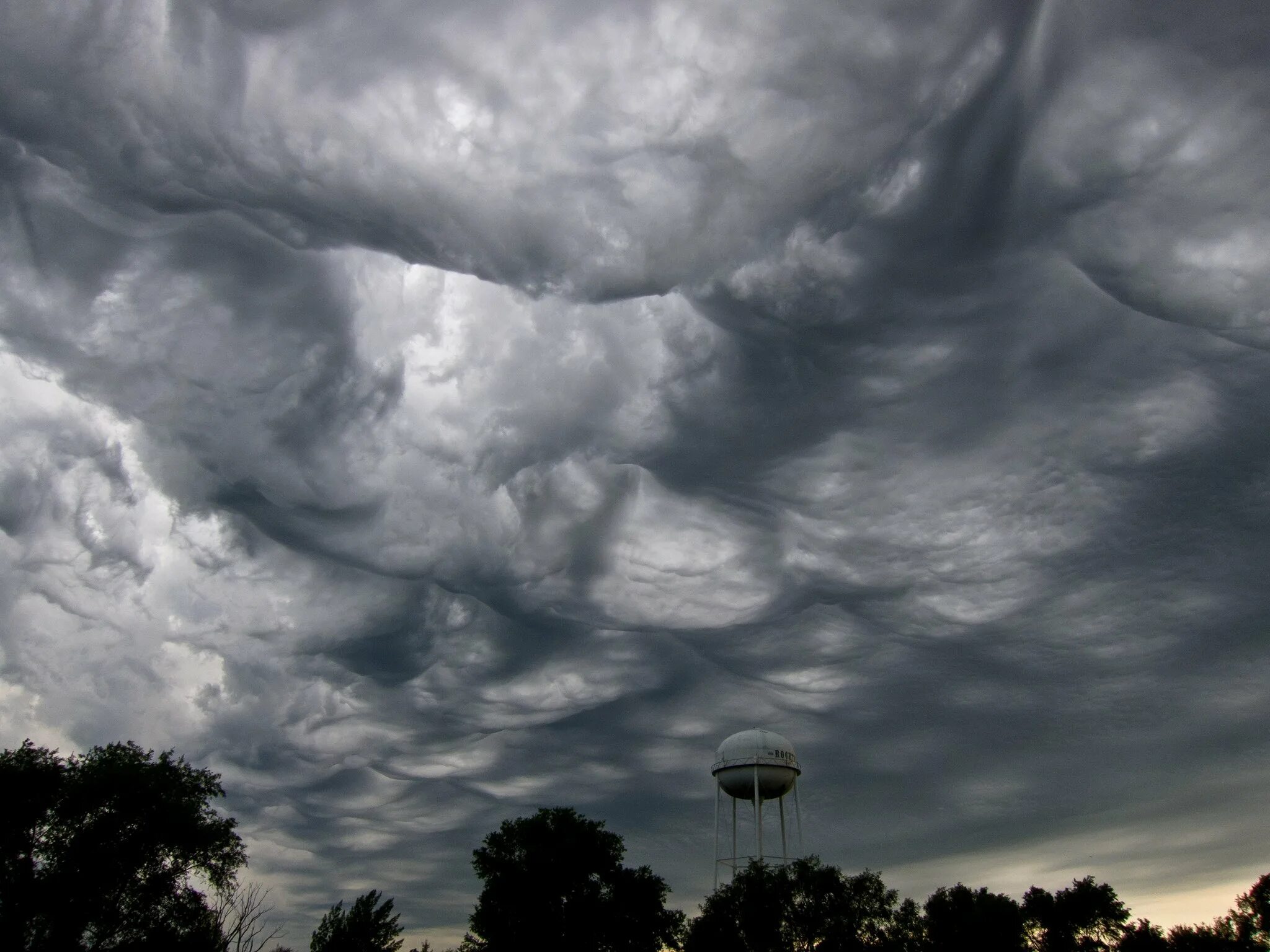 пасмурные облака. сосцевидные двояковыпуклые облака. грозовые облака над городом. дождливое небо. между серыми клочьями туч то показывались.