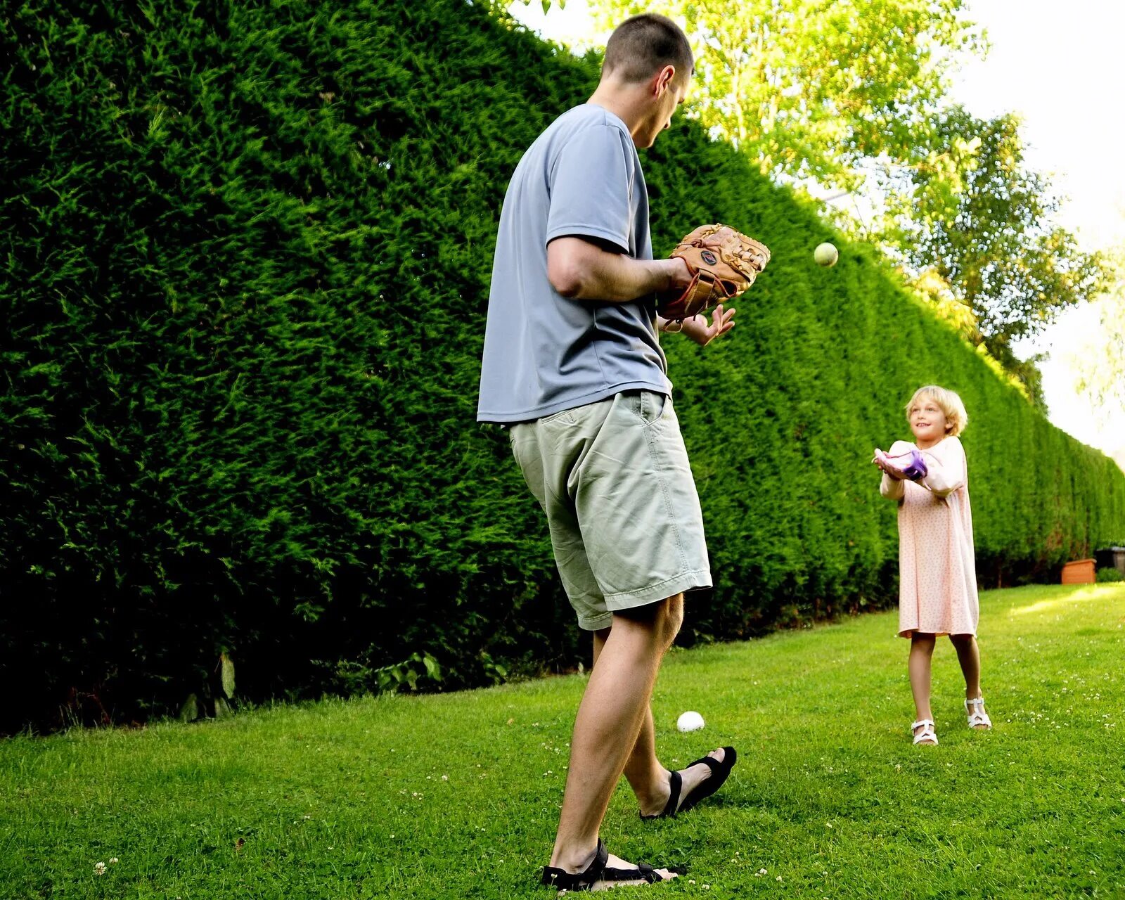 Helped to catch. Play catch. children playing catch. catching. family playing ball garden.