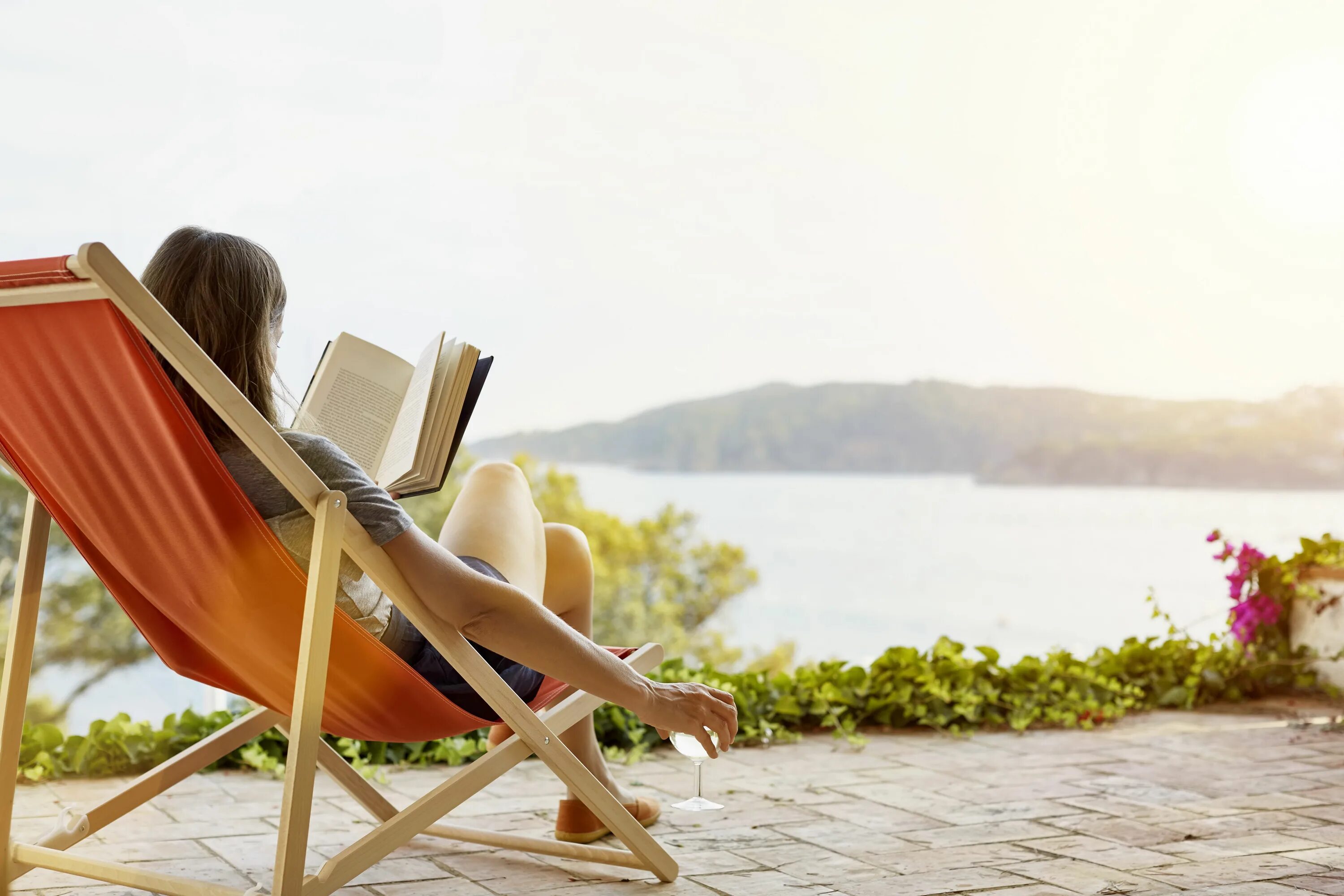 Повседневный отдых. Лето с книгой. Женщина на гамаке с книгой. Чтение на свежем воздухе. Чтение книг в гамаке.
