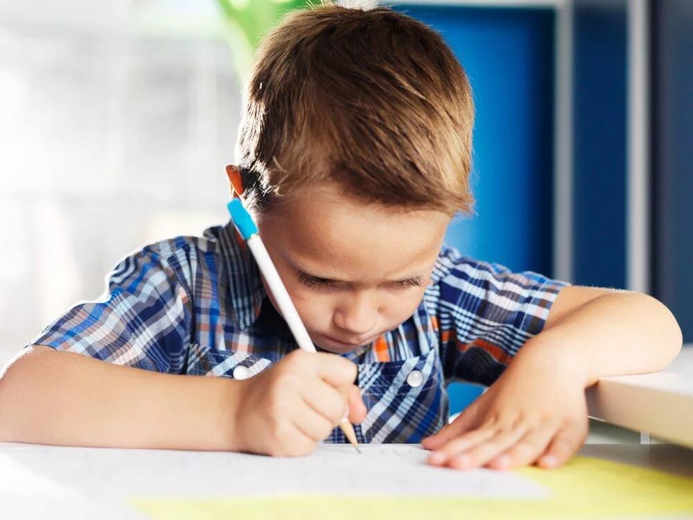 Прилежный мальчик. Старательный ребенок. Прилежный ребенок. Ученик с ручкой. Ребенок пишет.