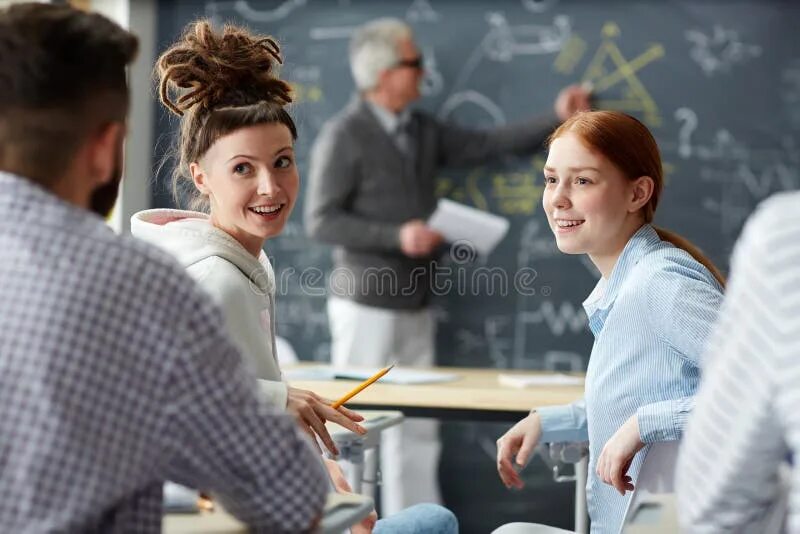 Talking at the lessons. Общение подруг на уроке. two students are talking.