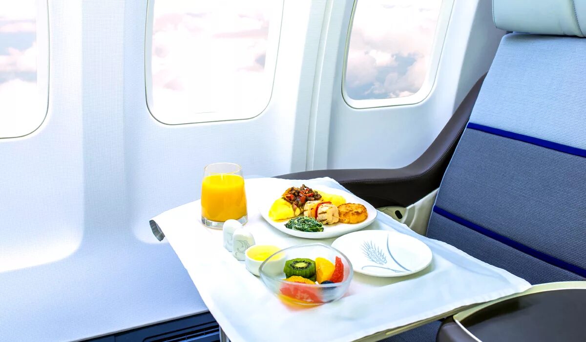 Самолете дают еду. Питание в самолете. Столик в самолете. Обед на борту самолета. Еда на борту самолета.