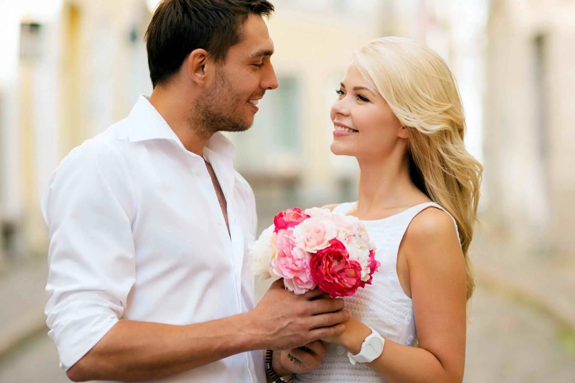 В мужа влюбилась девушка. Мужчина дарит цветы женщине. Парень дарит девушке цветы. Счастливая женщина. Мужчина и женщина с цветами.