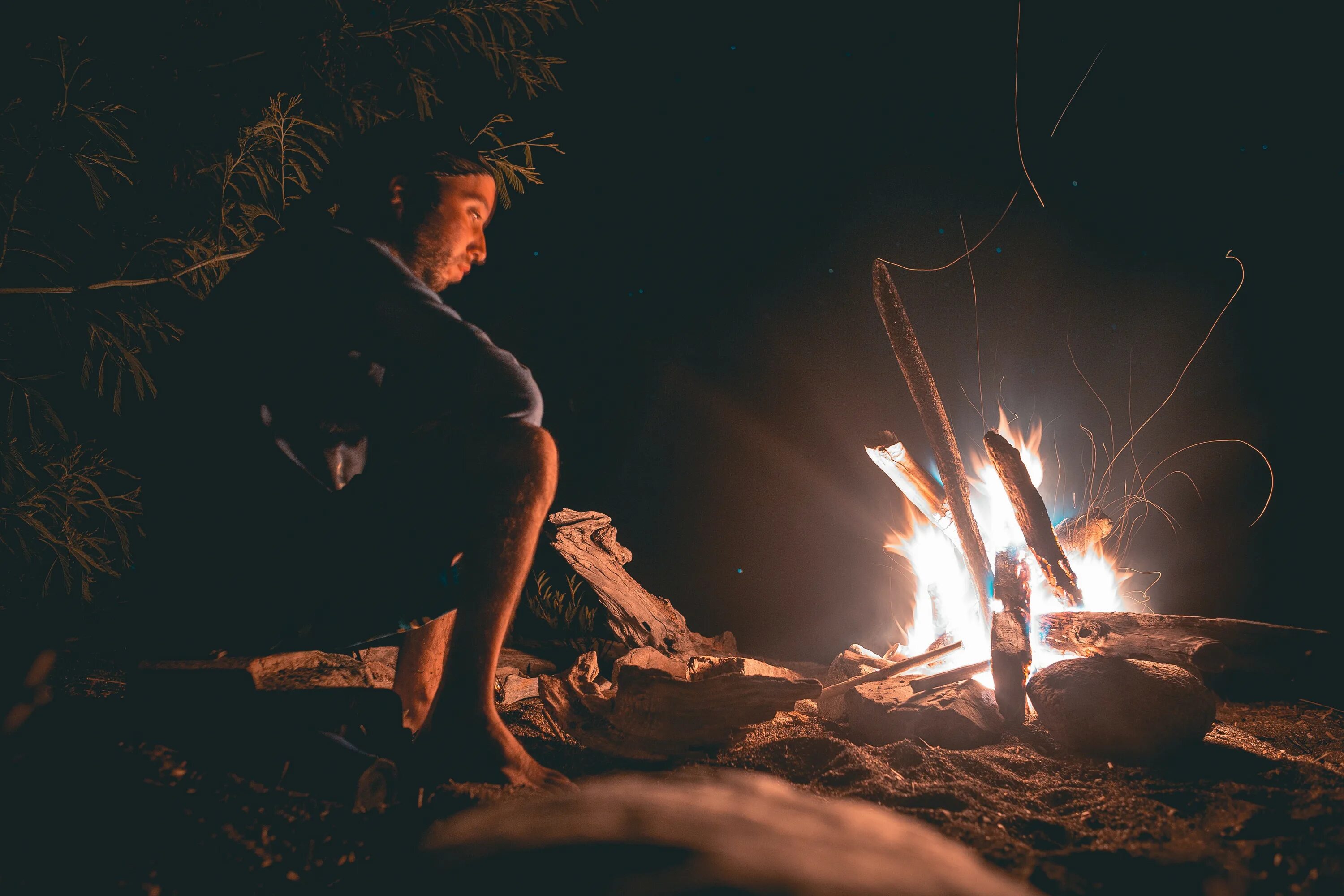 Near the fire. Люди сидят у костра. Девушка сидит у костра. Свет от костра на человеке. Девушка при свете костра.