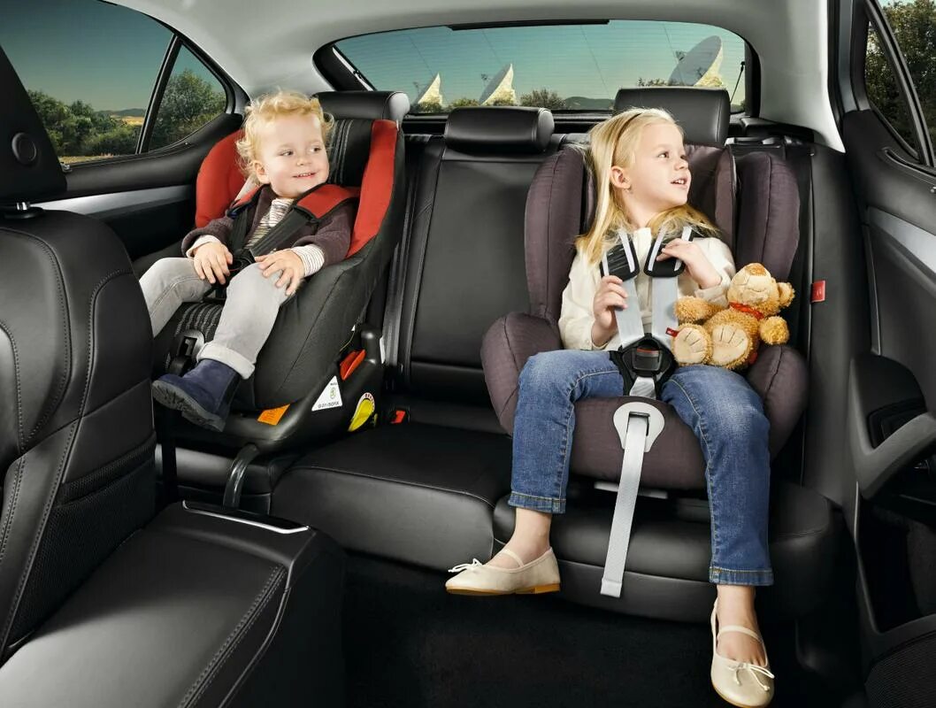 Безопасность ребенка на заднем сидение автомобиля. Двойное детское кресло в машину. Детское кресло на заднем сиденье. Ребенок в детском кресле. Два детских кресла на заднем сиденье.