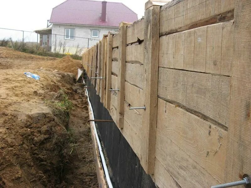 Доска для опалубки забора. Стянуть опалубку арматурой. опалубка из досок и шпилек. проволока для опалубки фундамента. стягивание опалубки проволокой.