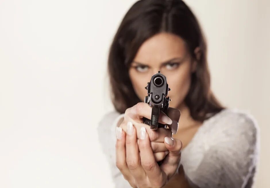 Девушка целится из револьвера. Целится из пистолета.