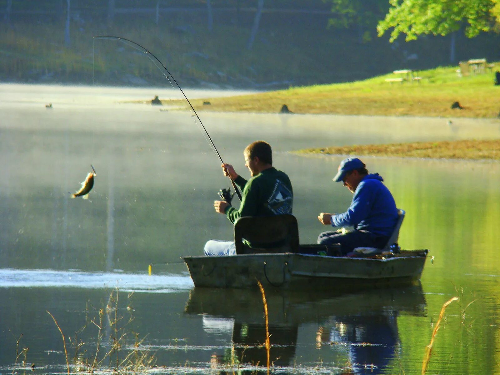 Ловить рыбу в городе. Рыбак в лодке. Рыбалка летом. Рыбалка на озере. Лодка для рыбалки.
