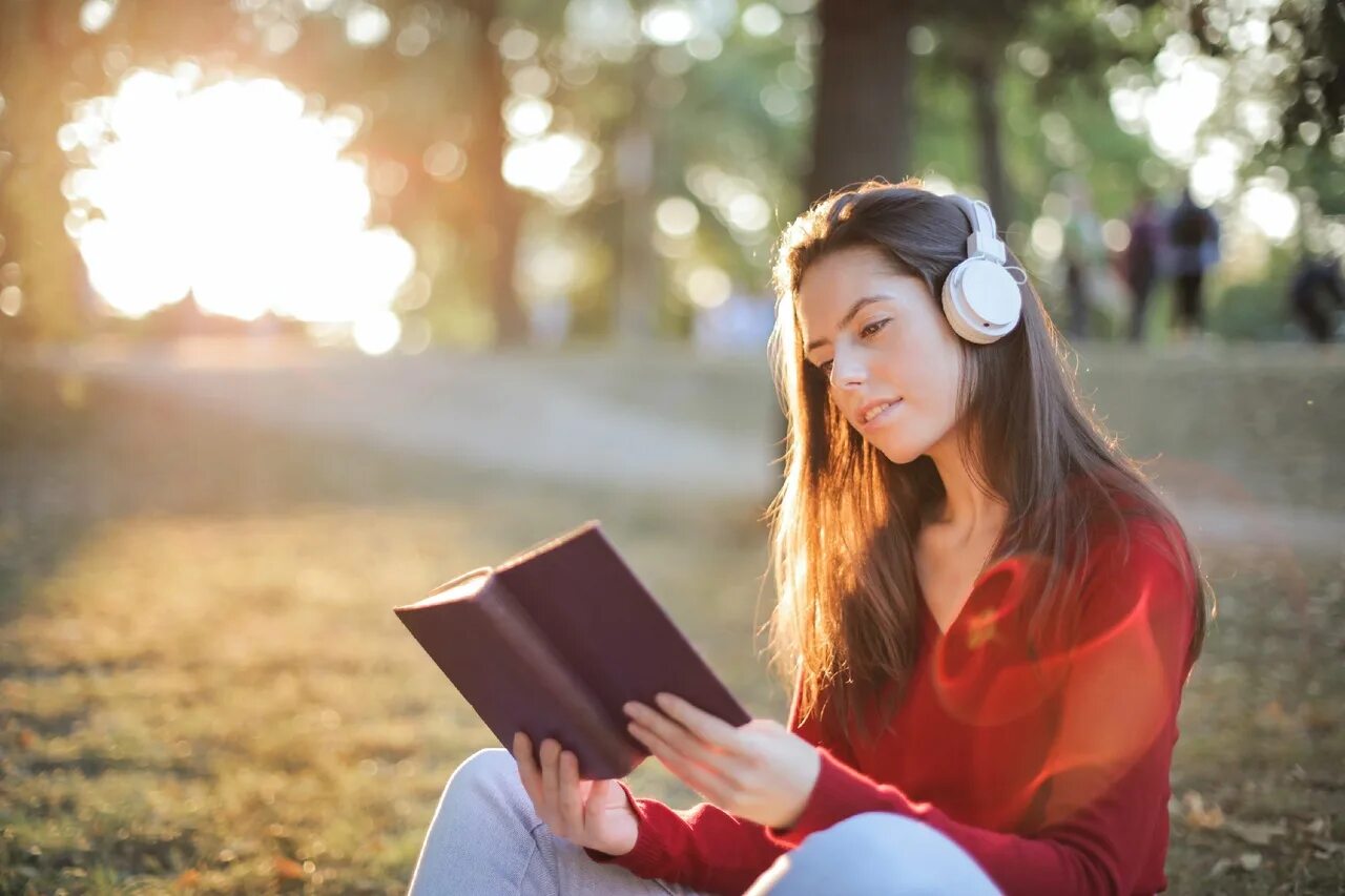 Читаем слушаем читаем. Чтение в наушниках. Чтение с наушниками. Читать книгу и слушать музыку. Девушка читает и слушает музыку.