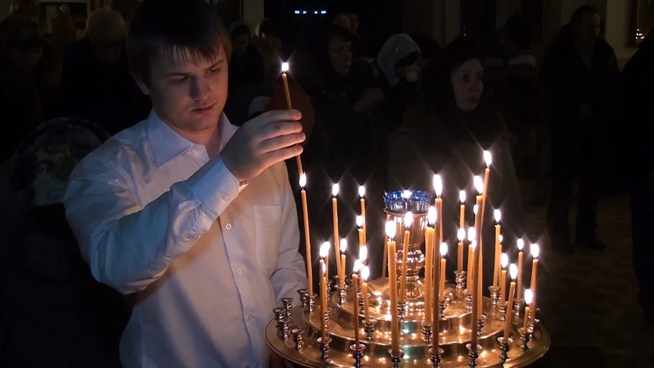 Мужчина ставит свечу. Свечи в храме. Человек свеча храм. Люди в храме. Горящие свечи в храме.