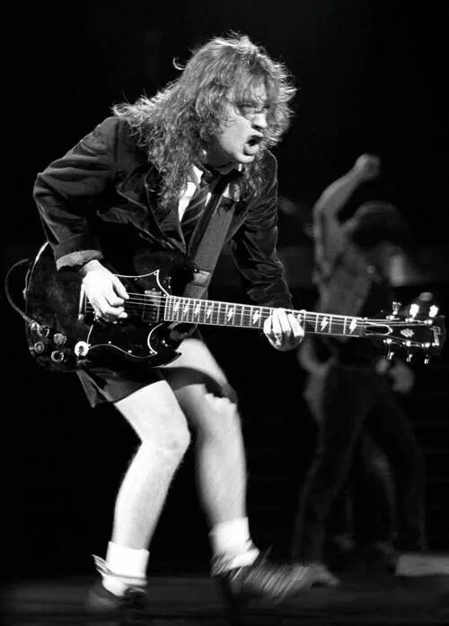 Гитарист AC DC Ангус. Angus young AC/DC гитара. AC DC Angus young молодой. Angus young в молодости.