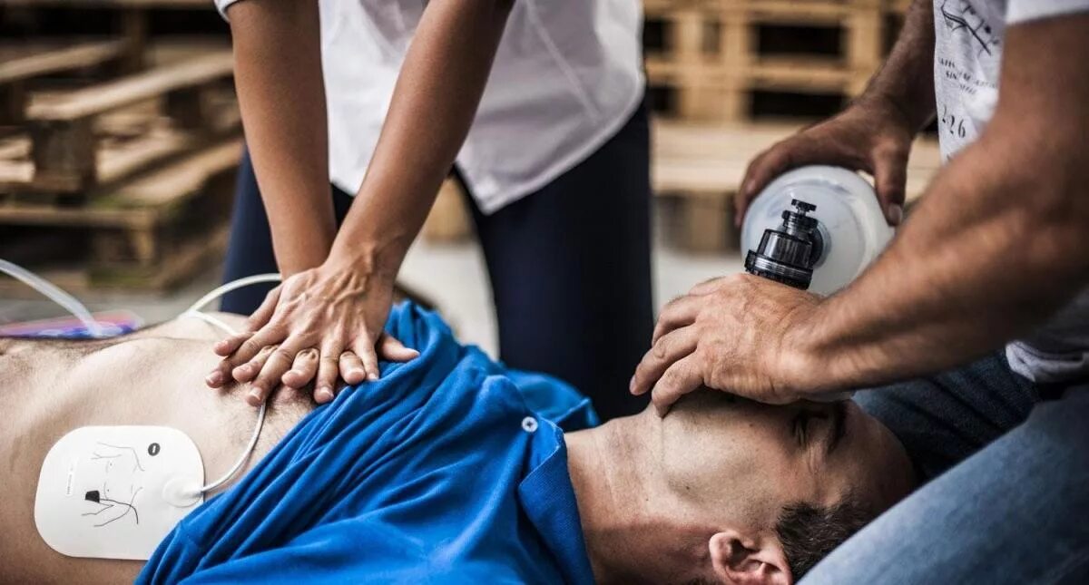 Человек в обмороке. Мужчины оказывают помощь. Мужчины оказывают помощь. Человек помогает другому. Мужчины оказывают помощь.