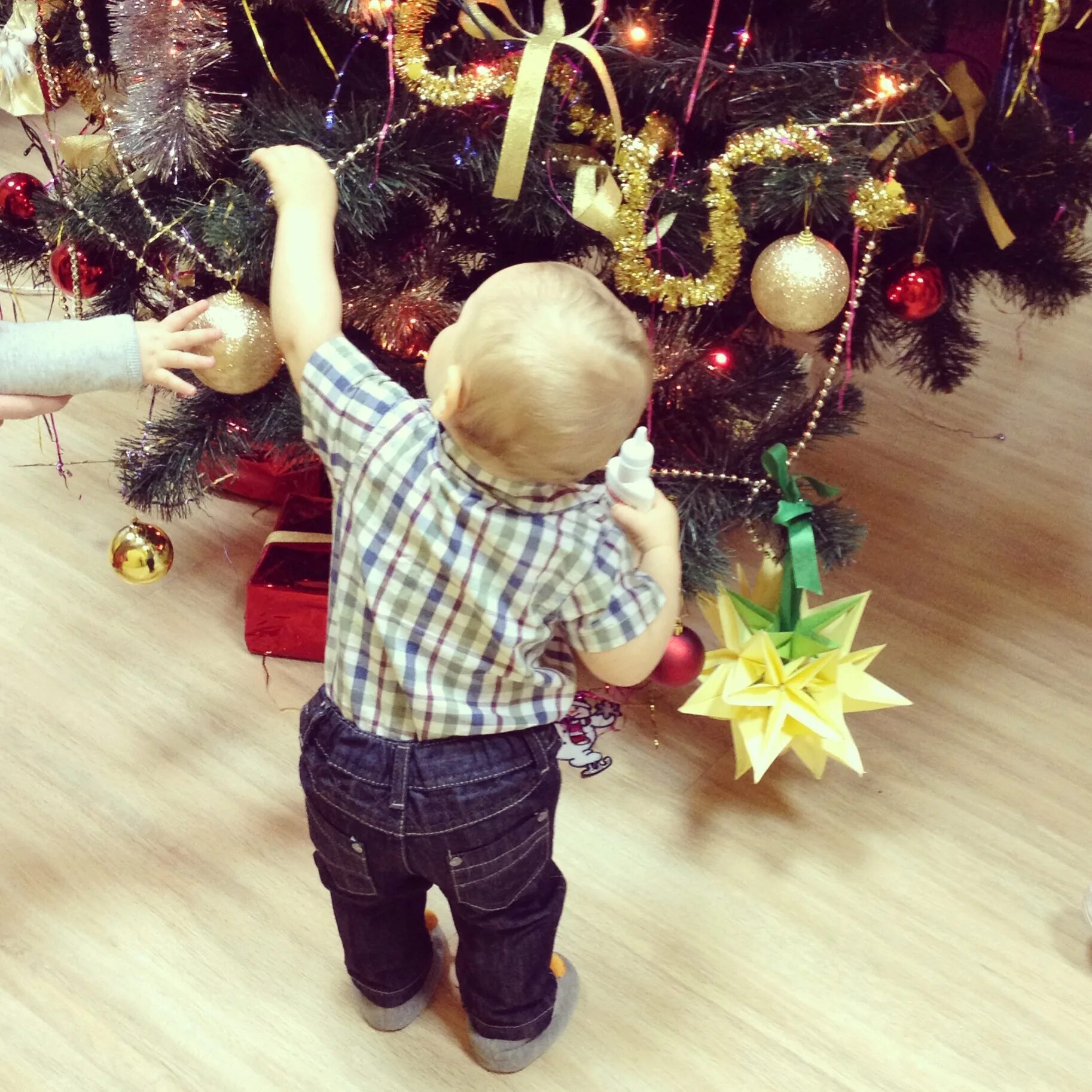 Друзья украшают елку. Малыш возле елки. Дети наряжают елку. Мальчик наряжает елку. Дети возле елки.