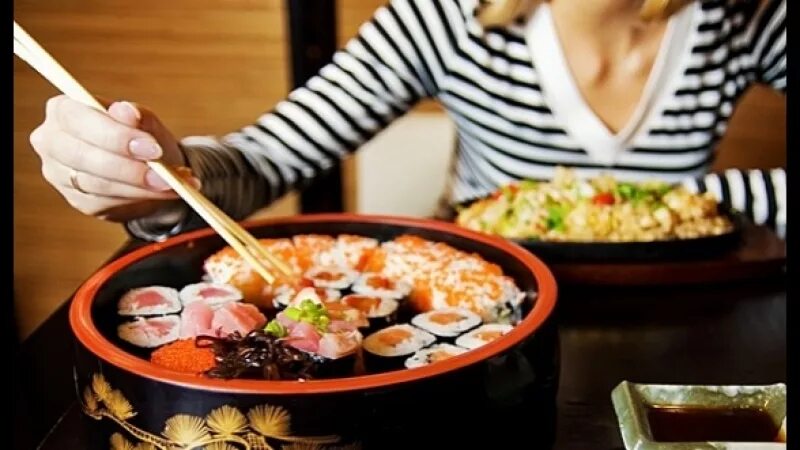 Беременные и роллы. Палочки для суши. Запрет в еде беременным. Девушка ест суши. Беременность аппетит.