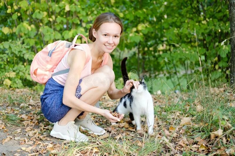 Девушка села на собака. Девушка сидит и гладит собаку. на корточках гладит собаку. девушка на корточках гладит кота. девушка на корточках гладит собаку.