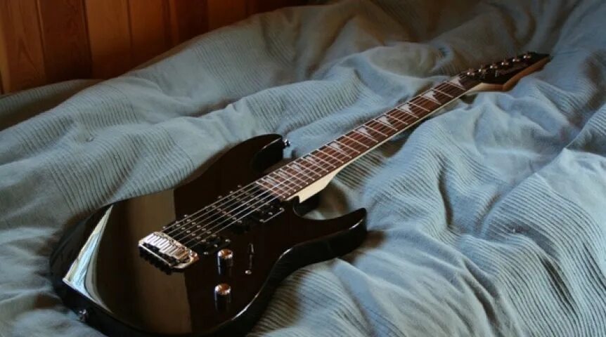 Ibanez GRX 4. Электрогитара лежит. Диван гитара. Электрогитара на кровати.