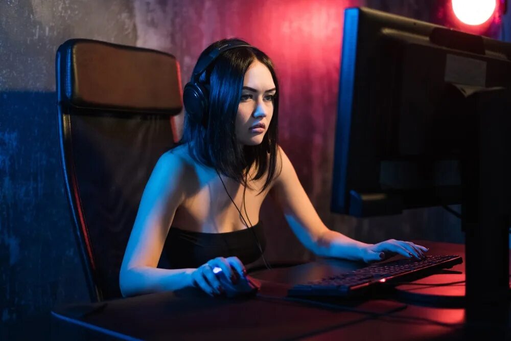 Девушка играет в игру. Девушка геймер за компьютером. девушка играет в компьютер. женщина за игровым компьютером. девушка играет за компьютером.